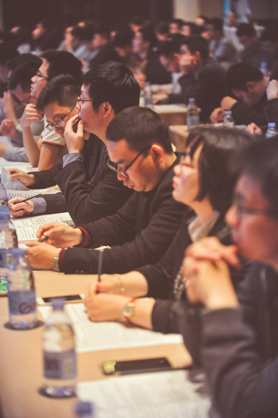 Professionals taking notes at a business conference table.