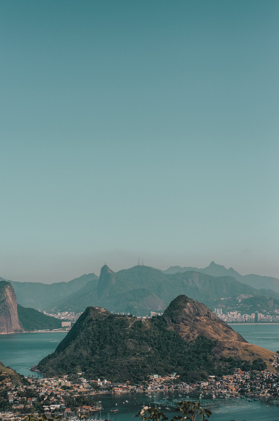 Aerial view of a coastal city beside mountains and a bay.
